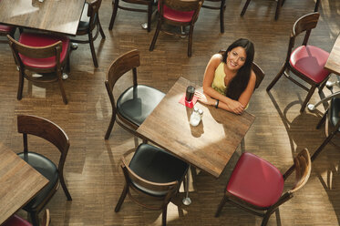 Germany, Munich, Young woman in cafe, smiling, portrait - RNF000537