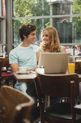 Germany, Munich, Couple with laptop in cafe - RNF000523