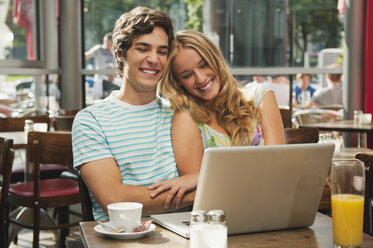 Germany, Munich, Couple with laptop in cafe - RNF000522