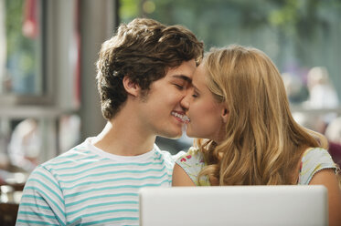 Germany, Munich, Couple kissing in cafe - RNF000519