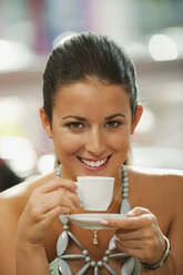 Deutschland, München, Junge Frau trinkt Kaffee im Cafe, lächelnd, Porträt - RNF000512