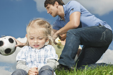 Germany, Cologne, Girl (2-3 Years) with hands clapsed, parents in background - WESTF015638