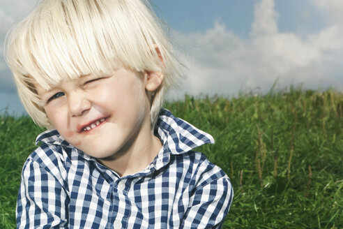 Deutschland, Köln, Junge (2-3 Jahre), der auf die Lippen beißt und zwinkert - WESTF015644