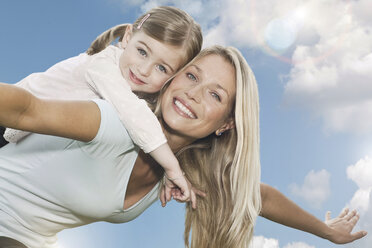 Germany, Cologne, Mother carrying her daughter (2-3 Years) on back, smiling, portrait - WESTF015670