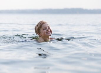 Germany, Ambach, Boy swimming in lake, smiling, portrait - HSIF000062