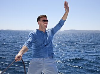 Croatia, Zadar, Young man waving from sail boat - HSIF000080