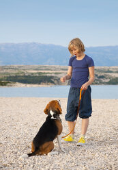 Croatia, Zadar, Girl with dog on beach - HSIF000107