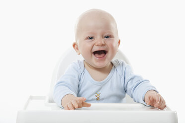 Kleiner Junge (6- 11 Monate) auf Hochstuhl, lachend, Porträt - RBF000430