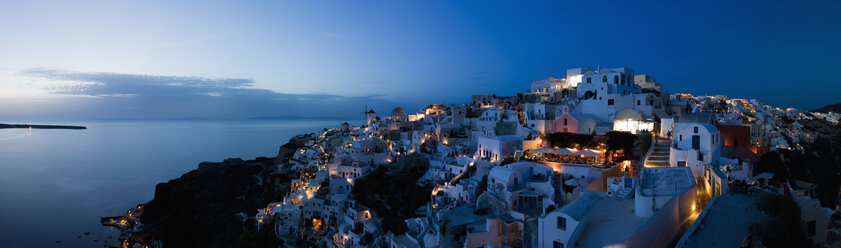 Griechenland, Kykladen, Thira, Santorin, Blick auf Oia und Windmühlen nach Sonnenuntergang - FOF002876