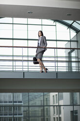 Germany, Bavaria, Business woman standing with bag - MAEF002711