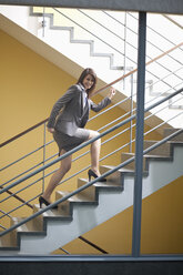 Germany, Bavaria, Business woman climbing stairscase - MAEF002755