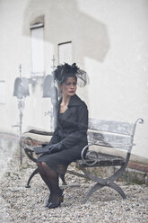 Germany, Bavaria, Young woman sitting on bench, looking away - MAEF002731