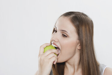 Young woman eating green apple - PDF000082