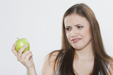 Junge Frau schaut auf grünen Apfel - PDF000083