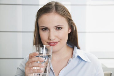 Deutschland, Köln, Junge Frau mit Glas Wasser, lächelnd, Porträt - PDF000115