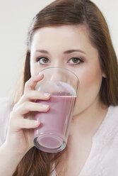 Germany, Cologne, Young woman drinking diet drink, portrait - PDF000149