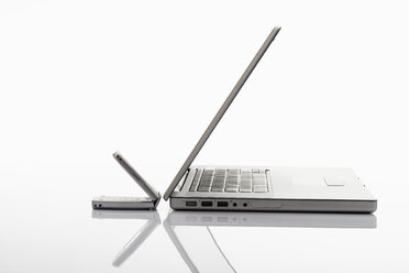 Laptop und Mobiltelefon auf weißem Hintergrund, Nahaufnahme - CSF014068