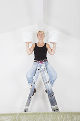 Deutschland, Köln, Reife Frau auf Leiter mit Farbeimern für Workout - GWF001370