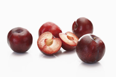 Red plums on white background, close up - CSF014137