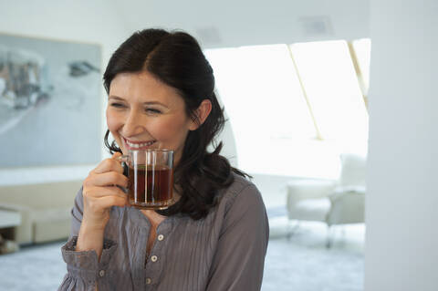 Deutschland, München, Ältere Frau hält Tasse, lächelnd, Porträt, lizenzfreies Stockfoto