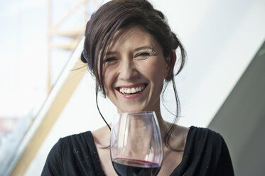 Germany, Munich, Mature woman with wine glass, smiling, portrait - NHF001311