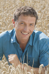 Germany, Bavaria, Man smiling in field, portrait - CRF002007