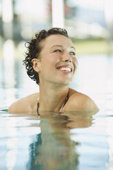 Italy, South Tyrol, Woman in swimming pool of hotel urthaler, smiling - WESTF015873