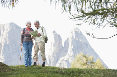 Italien, Südtirol, Älteres Paar mit Karte beim Wandern in den Dolomiten - WESTF015956