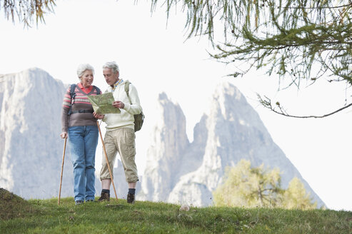 Italy, South Tyrol, Mature couple with map hiking on dolomites - WESTF015956