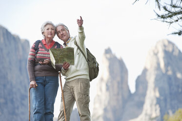 Italien, Südtirol, Älteres Paar mit Karte beim Wandern in den Dolomiten - WESTF015957