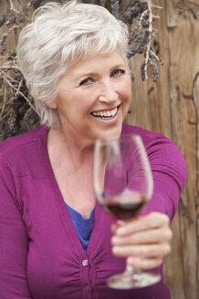 Italy, South Tyrol, Mature woman with wine glass, smiling, portrait - WESTF015989