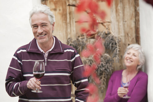 Italy, South Tyrol, Mature couple with wine glass at mountain hut - WESTF015998