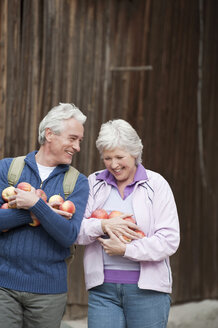 Italy, South Tyrol, Mature couple carrying apples, smiling - WESTF016001