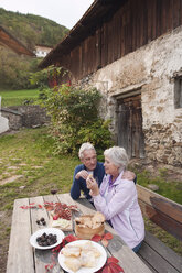 Italien, Südtirol, Älteres Paar bei der Brotzeit auf einer Berghütte - WESTF016016