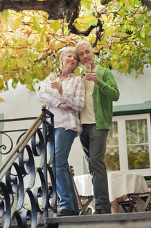 Italy, South Tyrol, Mature couple with wine glass at guesthouse - WESTF016026