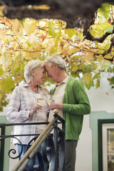 Italy, South Tyrol, Mature couple with wine glass at guesthouse - WESTF016027