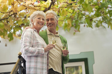 Italy, South Tyrol, Mature couple with wine glass at guesthouse - WESTF016029