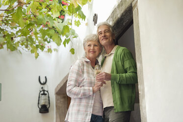 Italy, South Tyrol, Mature couple with wine glass at guesthouse - WESTF016030