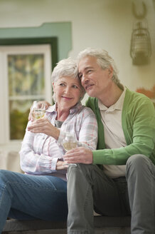 Italy, South Tyrol, Mature couple with wine glass at guesthouse - WESTF016032