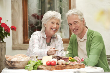 Italy, South Tyrol, Mature couple having their snacks at guesthouse - WESTF016037