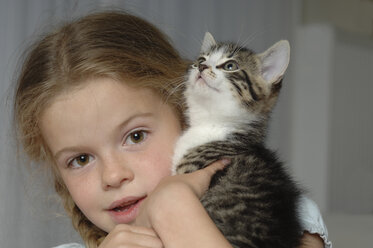 Germany, Bavaria, Girl holding her pet cat, portrait - CRF002035