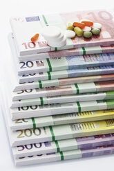 Tabletten auf einem Stapel von Euro-Noten, Nahaufnahme - CSF014285