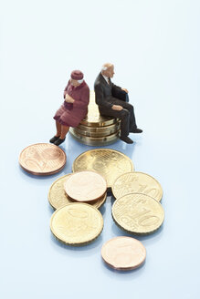 Figuren auf einem Stapel von Euro-Münzen sitzend - MAEF003028