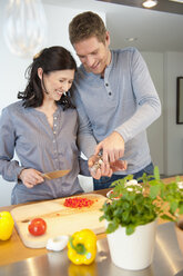 Germany, Munich, Man and woman cooking in kitchen, smiling - NHF001281