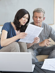 Germany, Munich, Mature couple doing paperwork - NHF001269