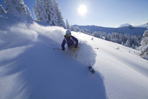 Österreich, Tirol, Kitzbühel, Junge Frau beim Skifahren, lizenzfreies Stockfoto