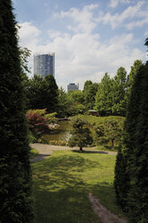 Deutschland, Nordrhein-Westfalen, Bonn, Blick auf japanischen Garten mit Hochhaus im Hintergrund - CSF014367