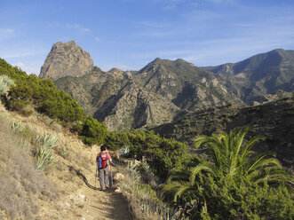 Spanien, Kanarische Inseln, La Gomera, Roque Cano, Barranco de la Era Nueva, Frau mit Rucksack beim Wandern in den Bergen - SIEF000066