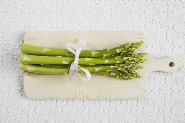 Bundle of green asparagus on chopping board, close up - GWF001377