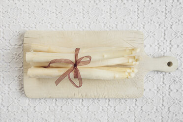 Bundle of white asparagus on chopping board, close up - GWF001378